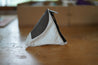 A Small pyramid shaped pouch made from white and black upcycled sailboat sail