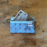 A Small Blue Trail Wallet with Keys a Credit Card and a 5 dollar bill