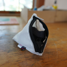 A Small pyramid shaped pouch with zipper opened revealing a headlamp inside