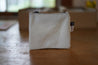 A small white rectangle pouch made from upcycled sailboat sail