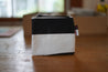 A small black and white rectangle pouch made from upcycled sailboat sail
